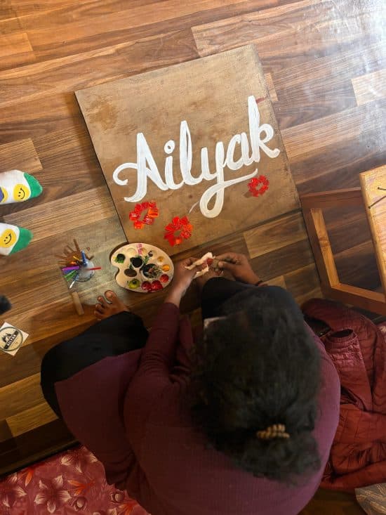 Participants painting in an art workshop at Ailyak