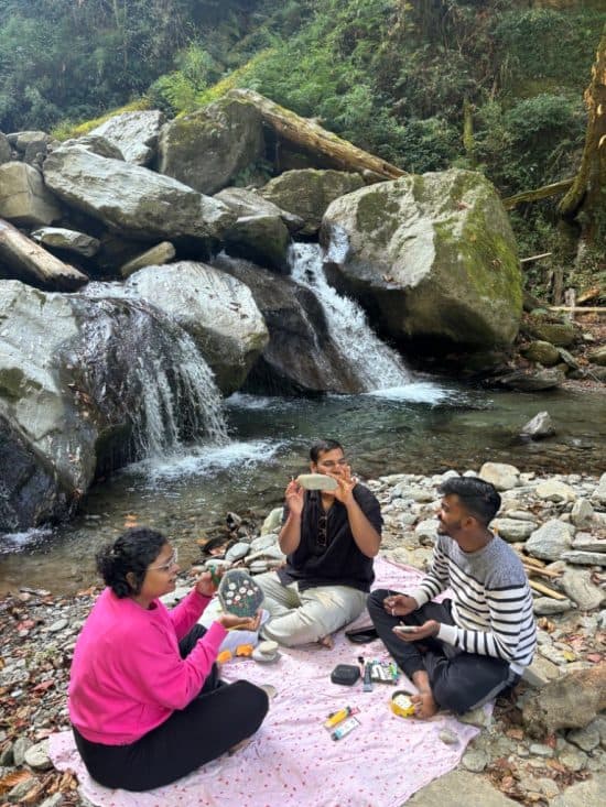 Artists painting on a scenic riverside