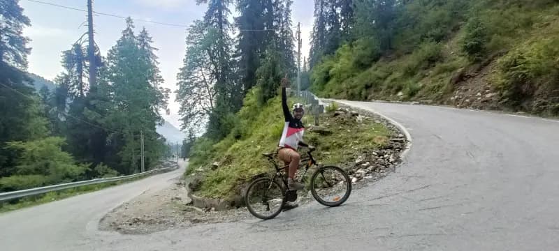 Biker on a lush forest trail in Jibhi