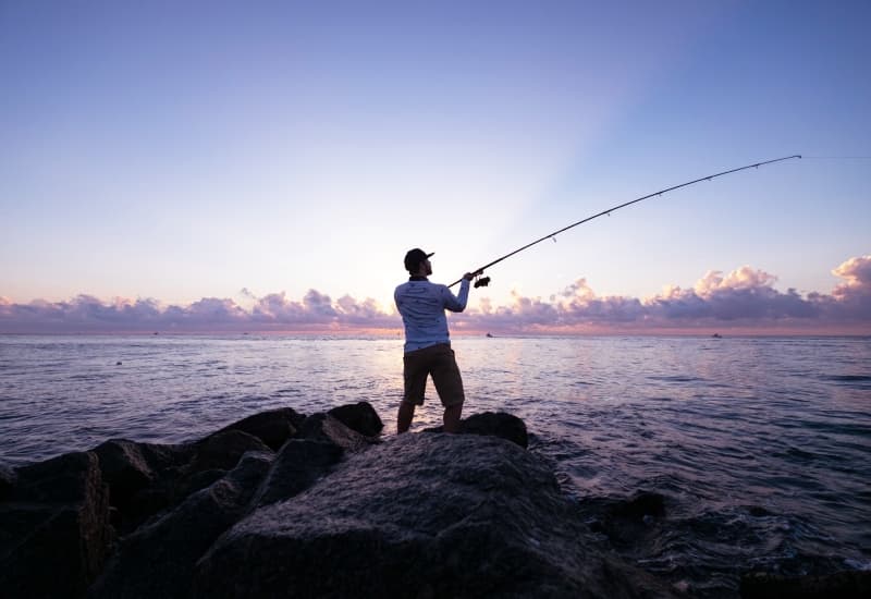 Fisherman casting a line in Tirthan River